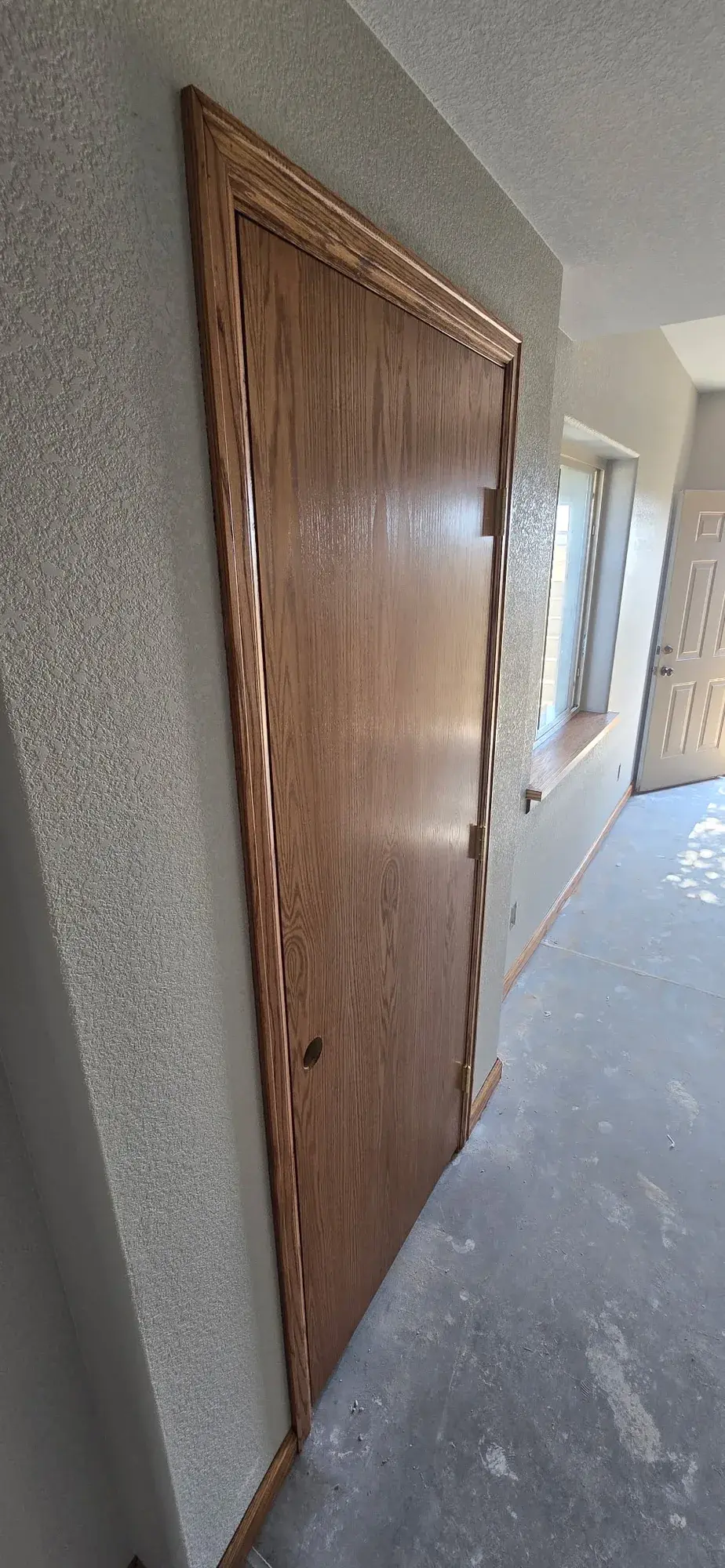 Interior wood door and trim detail beside freshly finished walls