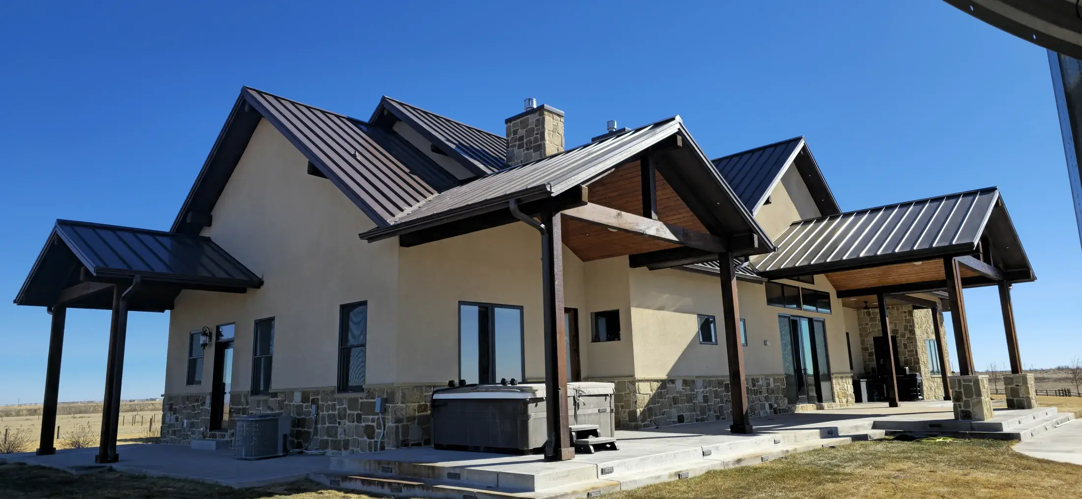 Custom home exterior with stucco, stone and dark wood architectural details