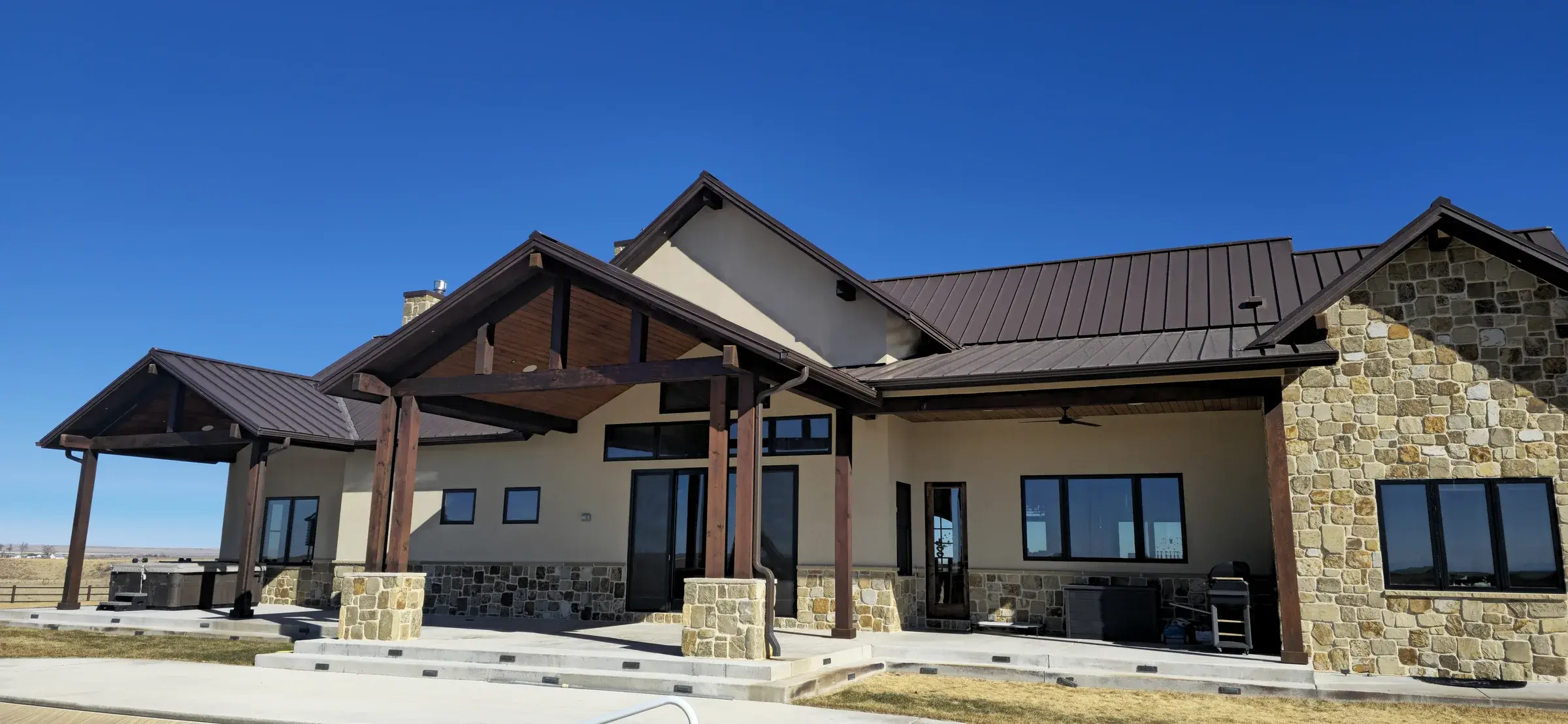 Wide rear elevation of a custom home showing coordinated exterior finishes