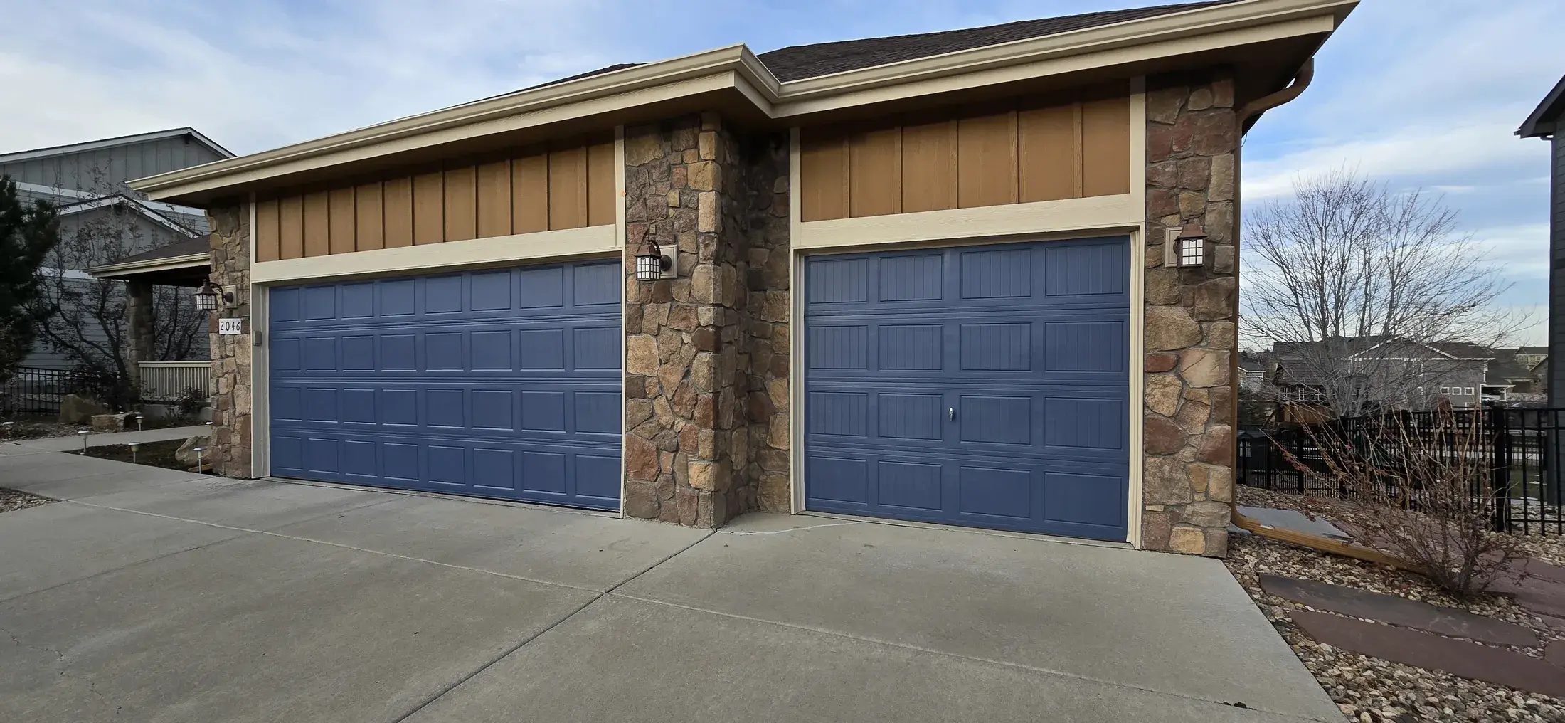 Two finished garage doors painted in a muted blue tone